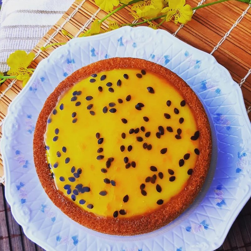 Torta de maracujá inteira, com creme amarelo e sementes, em prato azul