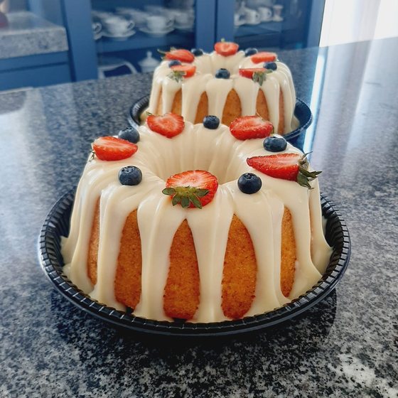 Bolos elegantes com glacê branco, morangos e mirtilos
